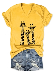 Detail of yellow V-neck T-shirt with cartoon giraffes and distressed denim shorts