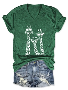 Flat lay of a green V-neck T-shirt with three giraffes and distressed denim shorts