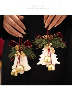 Gros plan d'une cloche de Noël en céramique blanche avec nœud en velours rouge et pomme