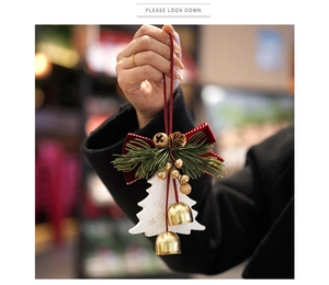 Détail d'un ornement de Noël avec pomme de pin, nœud en velours rouge et cloche