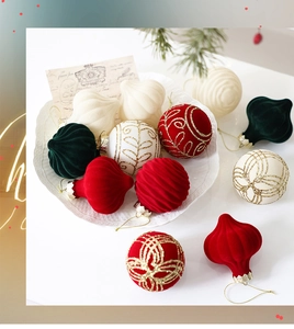 Macro shot of flocked Christmas ornaments with gold glitter patterns on a ceramic plate