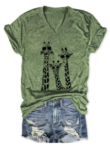 Flat lay of green V-neck giraffe print T-shirt paired with distressed denim shorts