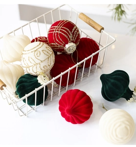 Detail of velvet flocked Christmas ornaments in red and green inside a white basket