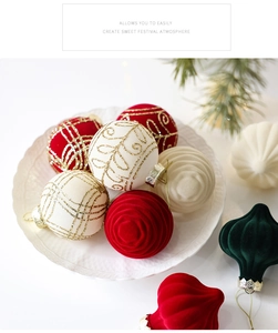 Detail of velvet Christmas balls with glitter swirls in a white ceramic dish
