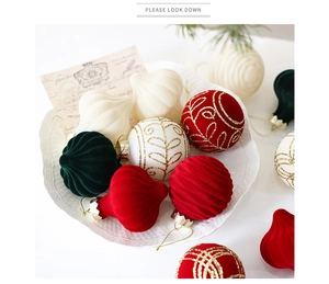 Detail of flocked Christmas ornaments with gold glitter patterns on a ceramic plate