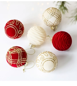 Detailed view of red and cream velvet Christmas balls with gold glitter patterns