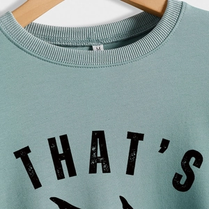 Sweat-shirt femme vert menthe avec col rond et imprimé artistique sur un cintre en bois