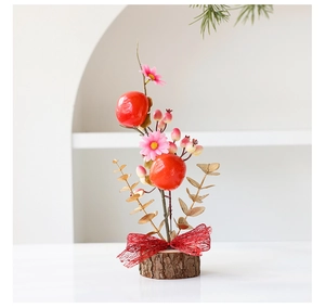 Detail of faux persimmons and eucalyptus leaves on a wooden base for festive decor