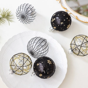 Set mit 8cm schwarz-goldenen Weihnachtskugeln mit Netzstoff auf einem Keramiktablett