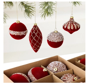 Detail of red flocked Christmas ornaments with white pearls and gold glitter in a gift box