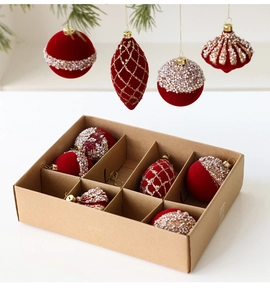 Detail of red flocked Christmas ornaments with pearl beads and gold glitter in a gift box