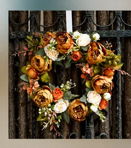 Détail d'une couronne de pivoines d'automne avec fleurs orange sur une clôture en bois