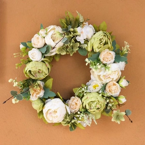 Couronne de pivoines crème vintage avec feuilles vertes et baies sur fond orange
