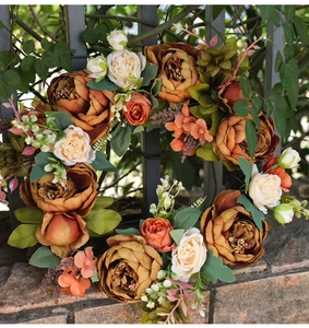 Detailed view of autumn peony wreath with orange flowers and foliage on stone background