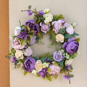 European vintage purple peony and white rose wreath hanging on a textured wall decor