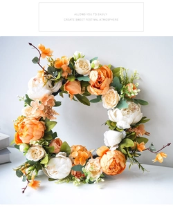 Detailaufnahme von handgefertigtem Pfingstrosenkranz mit orangefarbenen Rosen und Blättern