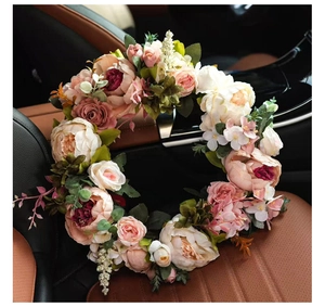 Detailed view of pink and cream artificial peonies on a lush floral wreath for door decor