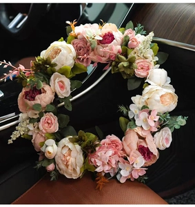 Detailed view of pink peonies and roses silk wreath resting on a brown leather car seat