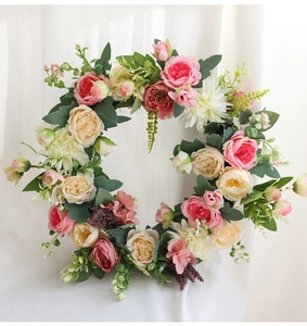 Détails de roses roses et dahlias blancs artificiels dans une couronne florale