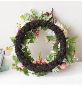 Détail de la base en rotin tressé et des roses roses artificielles de la couronne