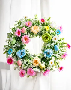 Detail of Easter wreath with colorful eggs, roses, and daisies on a white lace background