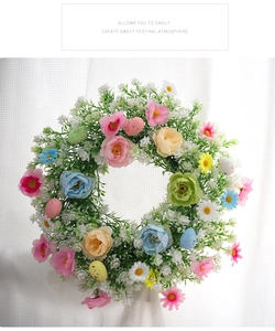 Detalle de corona de Pascua colorida con flores y huevos sobre fondo de ventana