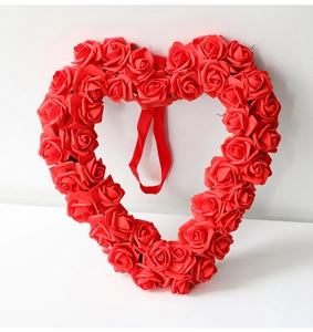 Detail eines roten Rosen-Herz-Kranzes mit künstlichen Blüten und rotem Aufhängungsband