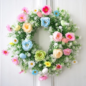 Corona de Pascua con huevos en tonos pastel y hojas de eucalipto para decorar la puerta