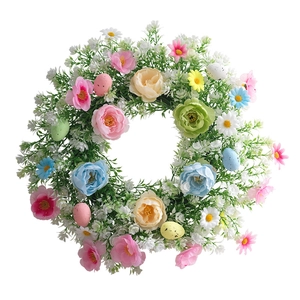 Corona de Pascua con flores primaverales coloridas y huevos para decorar puertas