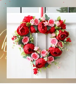 Detailed heart-shaped floral wreath with red peonies on a white wooden door decor