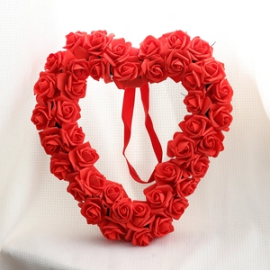 Roter Rosen Herz Kranz mit Band auf weißem Stoff für Valentinstag Dekoration im Haus