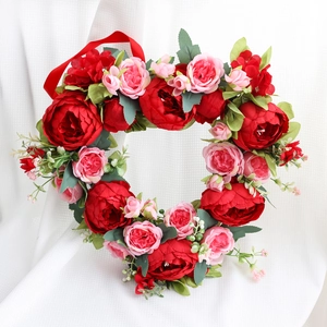 Romantic heart-shaped wreath with red peonies and pink roses on white background