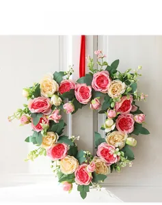 Detail of pink and cream faux rose heart wreath hanging on a white wooden door decor