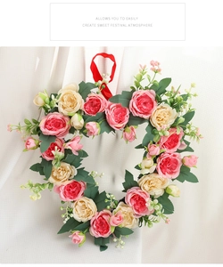 Close-up of heart-shaped floral wreath with pink roses and silk hanging strap