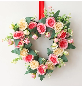 Detailed close-up of heart-shaped wreath with pink and cream roses for romantic wall decor