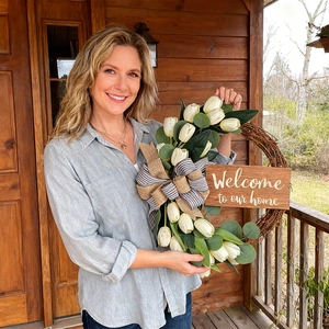 Detail of a welcome home sign on a rustic tulip wreath with a burlap bow and eucalyptus