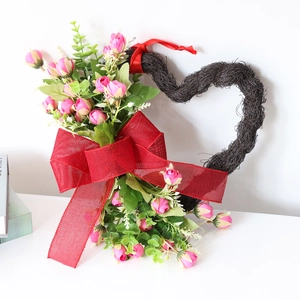 Corona romántica en forma de corazón con rosas rosas y un gran lazo rojo de malla