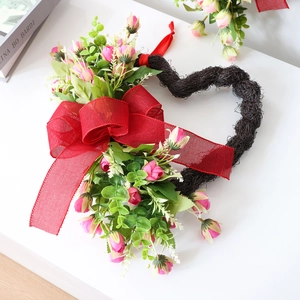 Corona artificial de corazón con rosas rosas, hojas verdes y lazo rojo para San Valentín