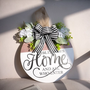 Rustic round wooden door wreath with BLESS THIS HOME sign and floral bow decor