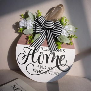 Rustic round wooden door wreath with 'Bless This Home' text and decorative bow