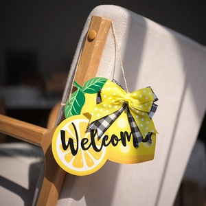 Detalle de cartel de bienvenida de madera con limones y lazo de lunares amarillos