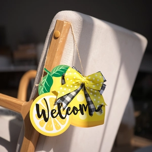 Detalle de placa de bienvenida de limón en madera con lazos y cuerda rústica