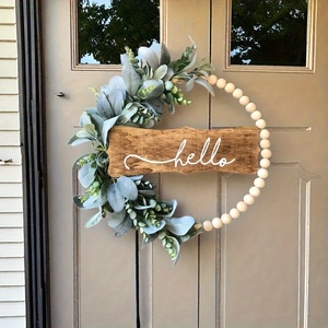 Autumn wooden bead wreath with eucalyptus leaves and hello sign hanging on a wooden door