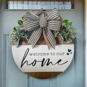 Close-up of rustic wooden welcome sign with bow and greenery on blue door
