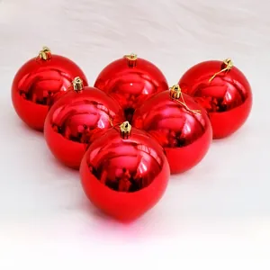 Macro detail of shiny red Christmas ornaments with gold caps on white plush surface