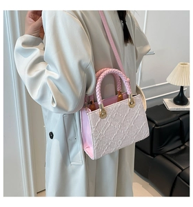 Detail of pink and white textured crossbody bag with braided handle and gold hardware