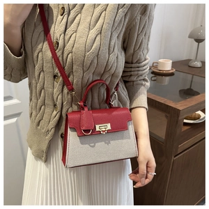 Detail of red pebbled leather and off-white woven small square bag with gold lock