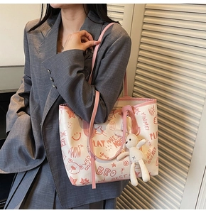 Détail d'un sac cabas avec imprimé ours graffiti rose et pendentif lapin en peluche