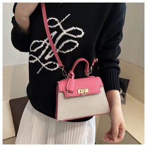 Detail of pink faux leather and cream canvas contrast bag with gold twist lock