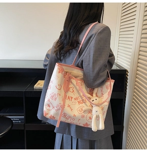 Détail du sac cabas imprimé avec graffitis de dessins animés et porte-clés lapin en peluche